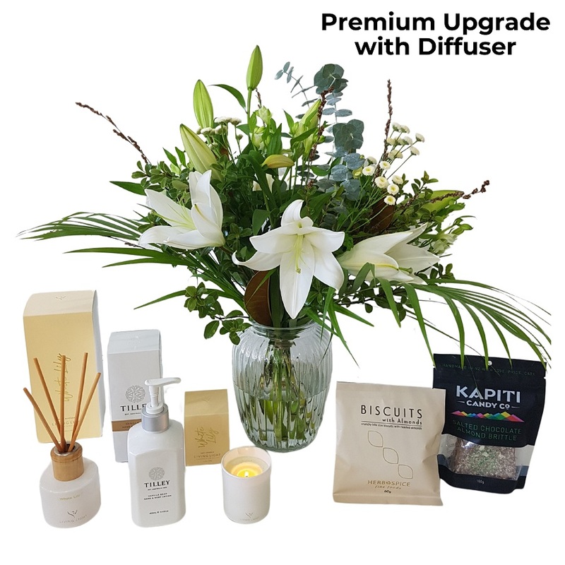 gift set of white flowers with scented pamper products and edible treats